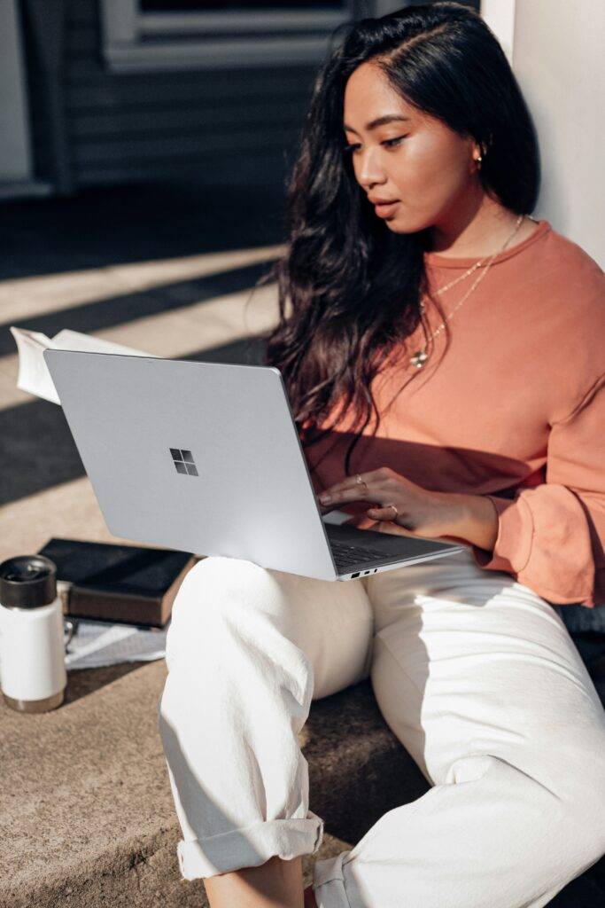 Female sitting on stairs on laptop