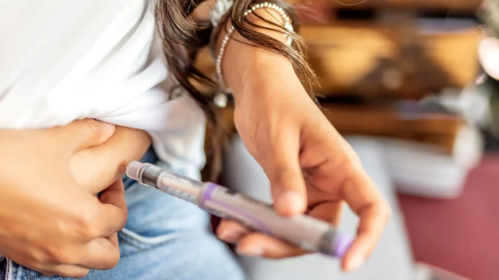 woman using injection pen GLP-1 weight loss experience medication routine